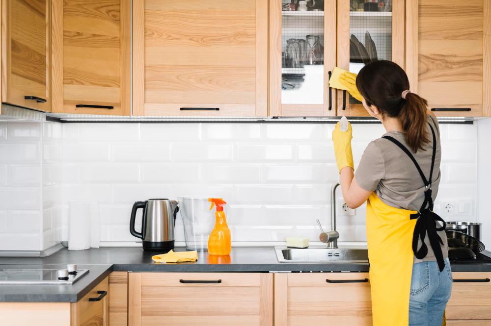 Woman sanitizing kitchen cabinets